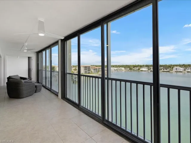 Unfurnished sunroom with expansive windows, a water view, and tile patterned floors