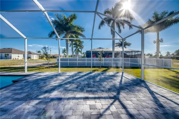 View of patio featuring glass enclosure, a sunroom, and an outdoor pool