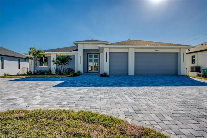 View of front of house featuring decorative driveway, a garage, and stucco siding
