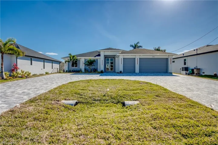 Single story home featuring decorative driveway, a garage, a front yard, and stucco siding