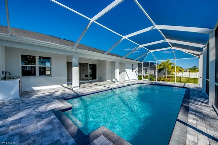Swimming pool featuring a sunroom, a lanai, and a patio