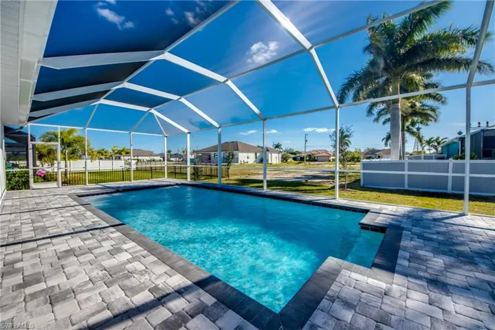 View of swimming pool featuring a sunroom, a lanai, a residential view, and a patio area