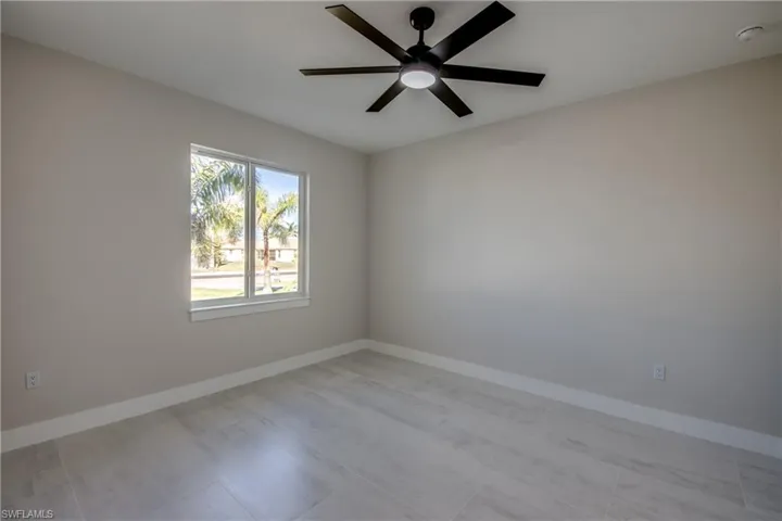 Spare room with baseboards and a ceiling fan