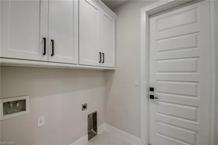 Laundry room with hookup for an electric dryer, cabinet space, and hookup for a washing machine