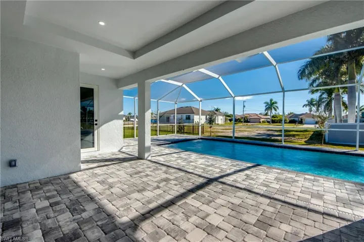 Outdoor pool featuring a patio area, a lanai, a residential view, a sunroom, and a lawn