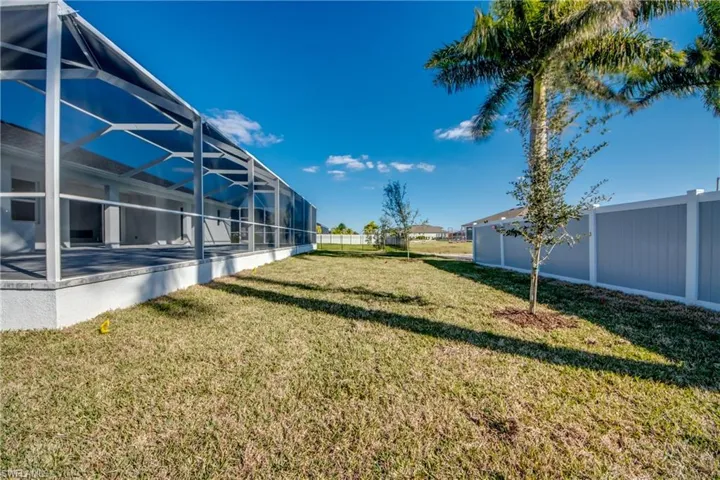 Fenced backyard with glass enclosure and a sunroom