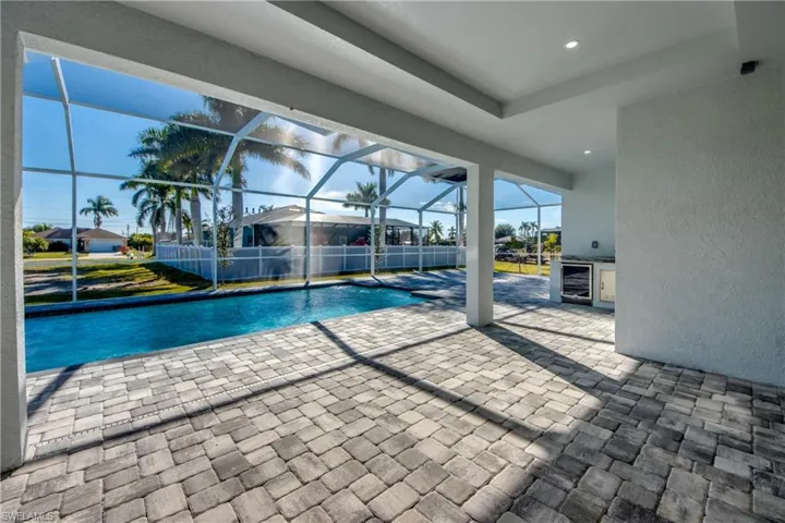 Swimming pool with a patio, glass enclosure, and a sunroom
