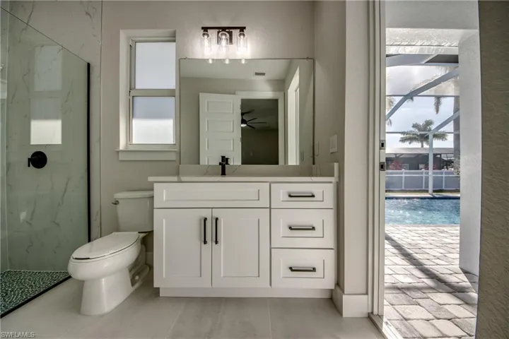 Bathroom featuring vanity and a marble finish shower