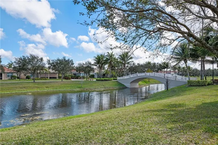28196 Jewel Fish Ln Bonita Springs FL 34135 - Lake view on side of home with pedestrian bridge in the distance