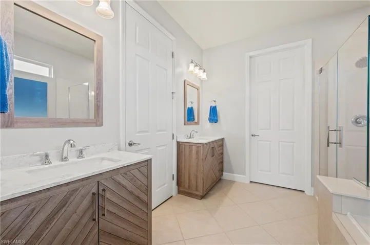 28196 Jewel Fish Ln Bonita Springs FL 34135 - Owner's bath with dual sinks, separate vanities, and a private commode