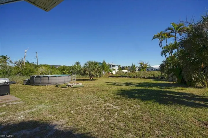 View of grassy yard with an outdoor pool