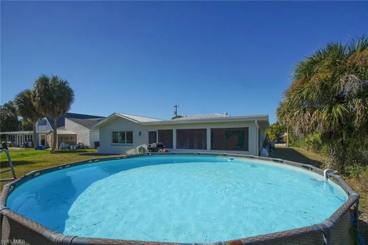 Swimming pool featuring a sunroom and a lawn