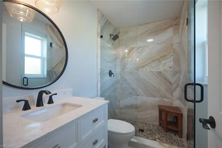 Bathroom featuring a shower stall and vanity