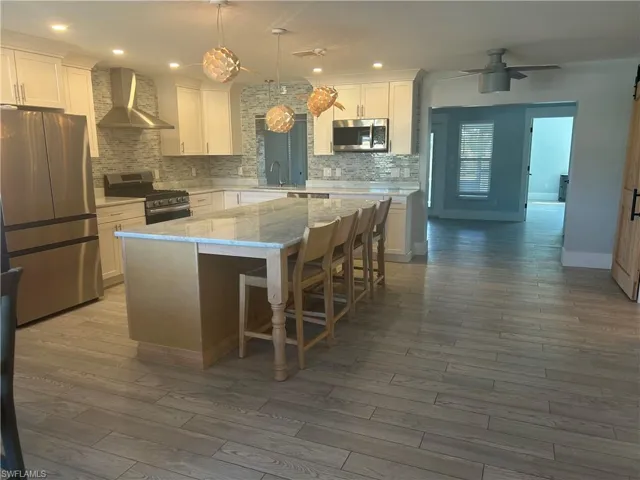 Kitchen featuring stainless steel appliances, white cabinets, and a center island