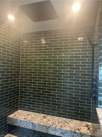 Full bath featuring a tile shower with