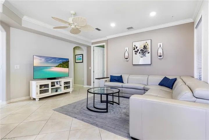Tiled living room featuring crown molding and ceiling fan