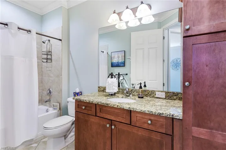Full bathroom featuring tile patterned floors, toilet, ornamental molding, vanity, and shower / bath combo
