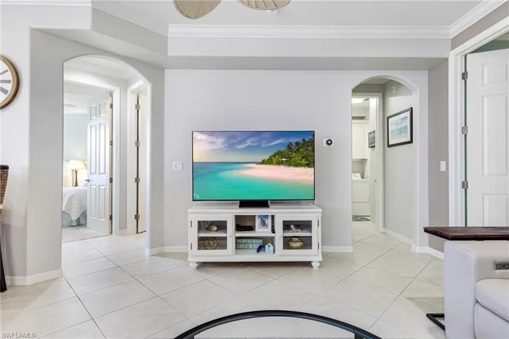 Tiled living room with washer / dryer and ornamental molding