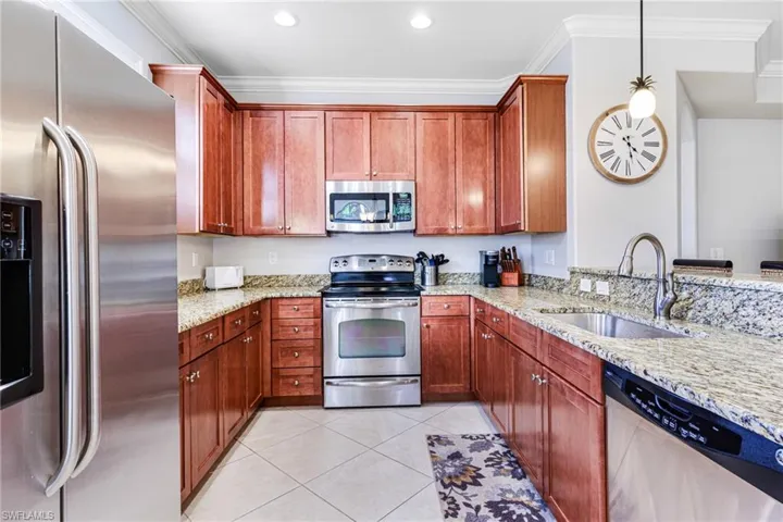 Kitchen with stainless steel appliances, crown molding, sink, and decorative light fixtures