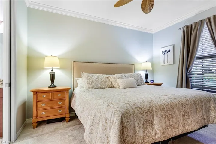 Bedroom featuring crown molding, light colored carpet, and ceiling fan