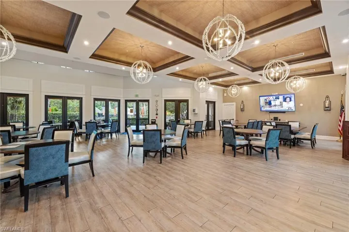 Dining room featuring a high ceiling, light hardwood / wood-style floors, a chandelier, and french doors