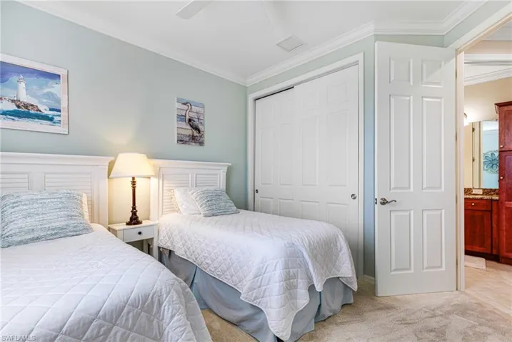 Bedroom with ornamental molding, light colored carpet, ceiling fan, and a closet