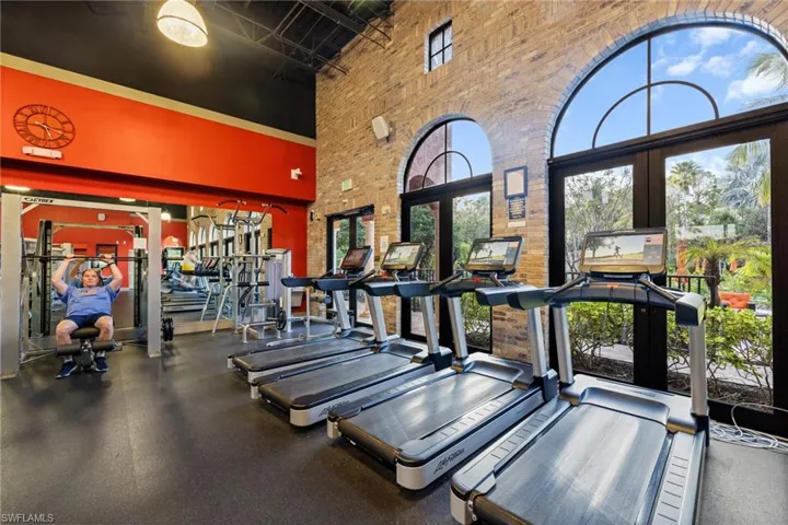 Workout area featuring a wealth of natural light, french doors, and a high ceiling