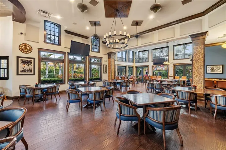 Dining room with dark hardwood / wood-style flooring, a towering ceiling, and decorative columns