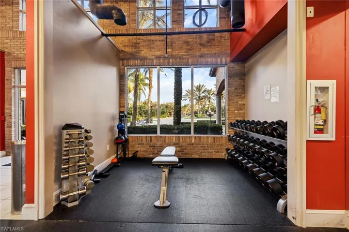 Gym featuring a high ceiling and brick wall
