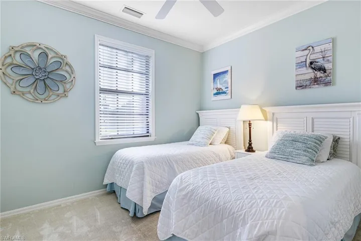 Bedroom with light carpet, ornamental molding, and ceiling fan