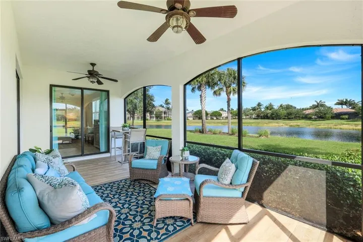 Sunroom with a ceiling fan and a water view