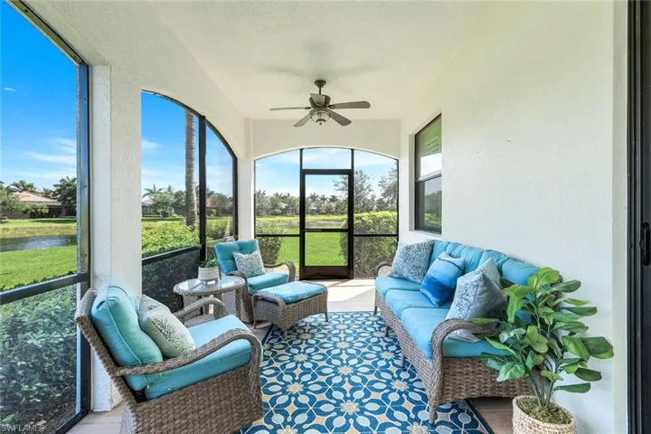Sunroom featuring a ceiling fan, a water view, and an outdoor living space