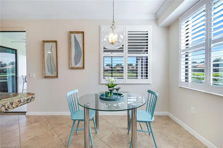 Dining space featuring a chandelier, crown molding, baseboards, and light tile patterned floors