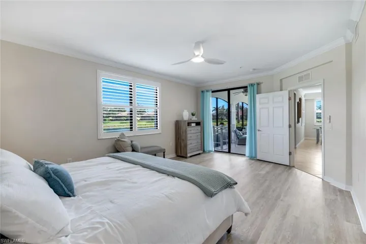 Bedroom featuring access to outside, light wood-type flooring, crown molding, baseboards, and a ceiling fan