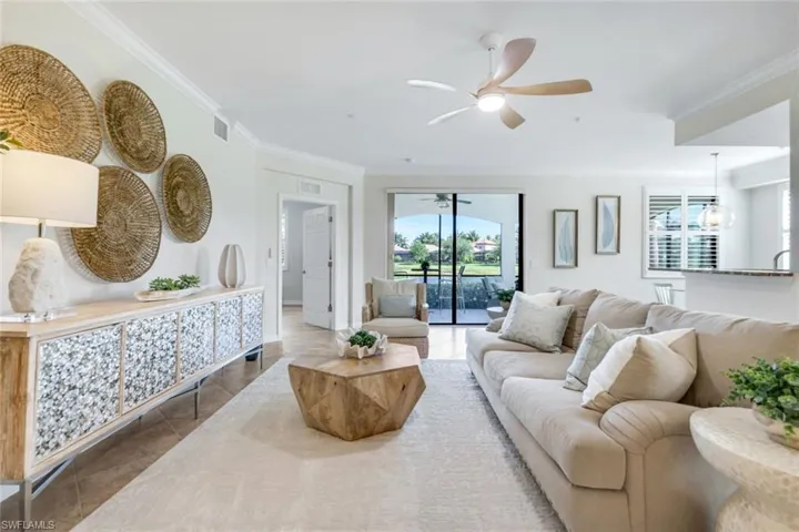 Living area with a ceiling fan, tile patterned floors, and ornamental molding