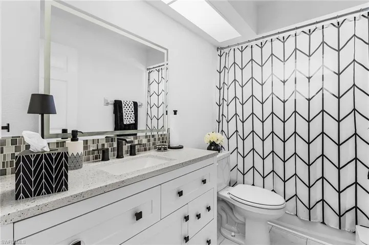 Full guest bath with vanity, decorative backsplash, and a tub and shower combination and new high profile toilet