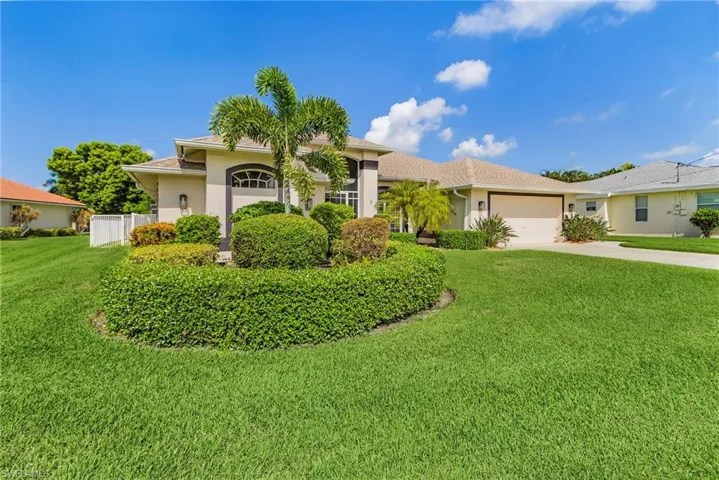 View of front of property featuring stucco siding, concrete driveway, a front lawn, a garage, and a shingled roof