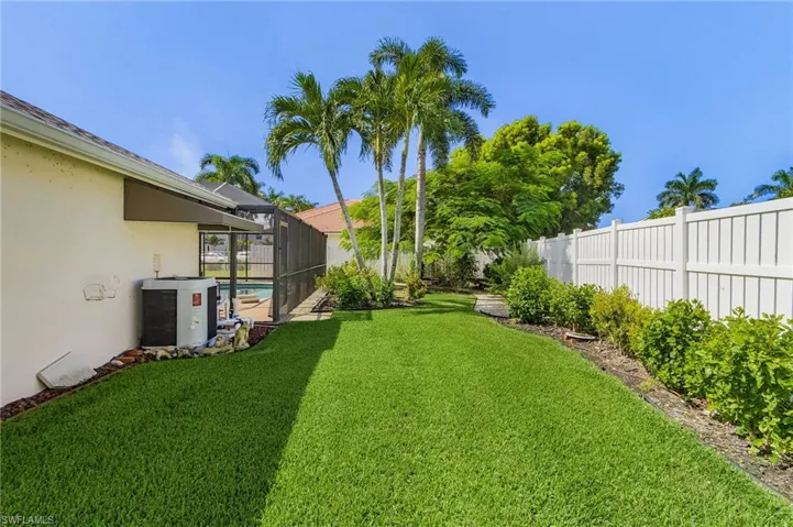 Fenced backyard featuring screen enclosure and a under truss lanai and pool heater