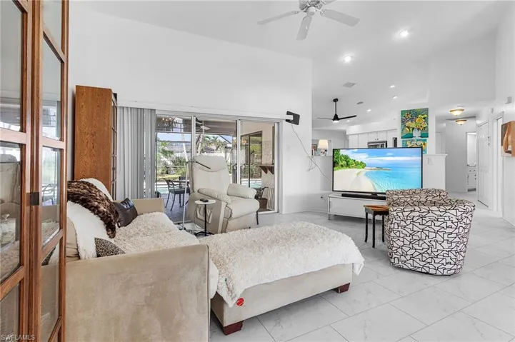 Living area with high vaulted ceiling, recessed lighting, and light marble finish floors(luxury vinyl flooring) with access to the hallway to guest bedrooms and bath and huge storage closet in the hallyway