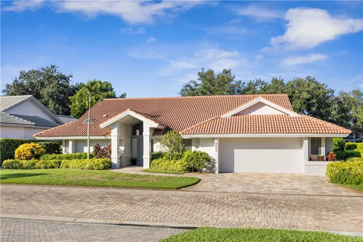Mediterranean / spanish home with a garage, driveway, stucco siding, a tile roof, and a front yard