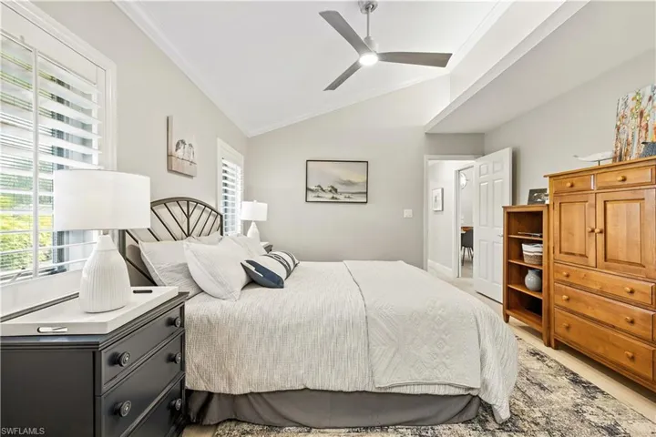 Bedroom with ornamental molding, vaulted ceiling, and ceiling fan