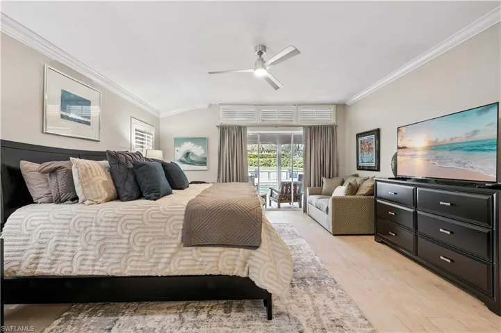 Bedroom featuring ornamental molding, light wood-type flooring, access to outside, and a ceiling fan