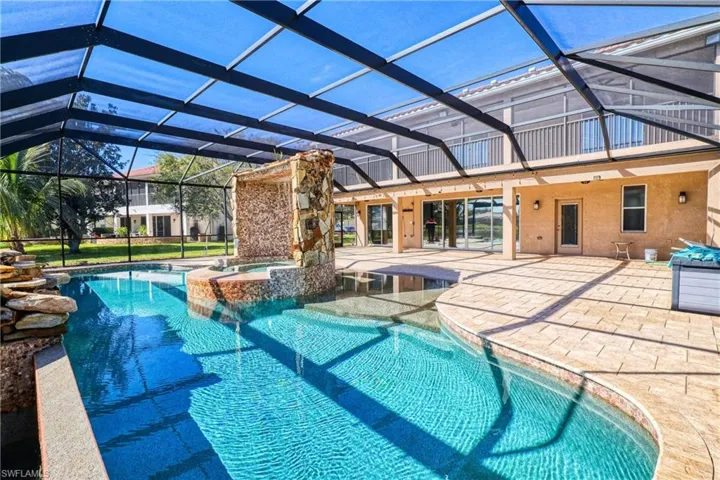 View of swimming pool with a lanai, a patio, and an in ground hot tub