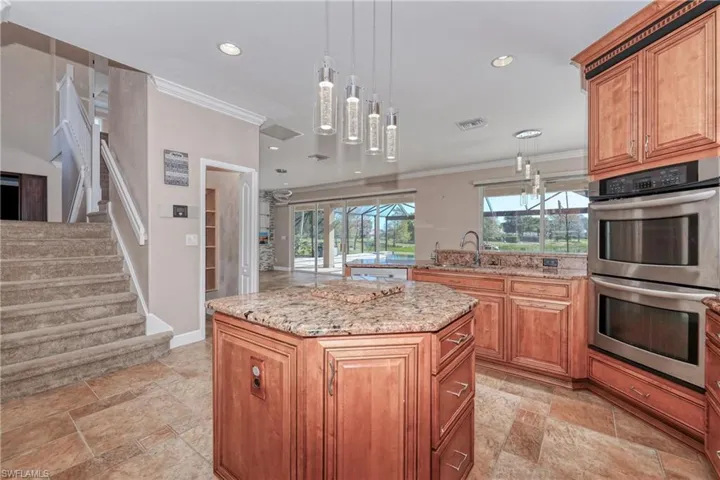 Kitchen with sink, crown molding, a kitchen island, pendant lighting, and stainless steel double oven