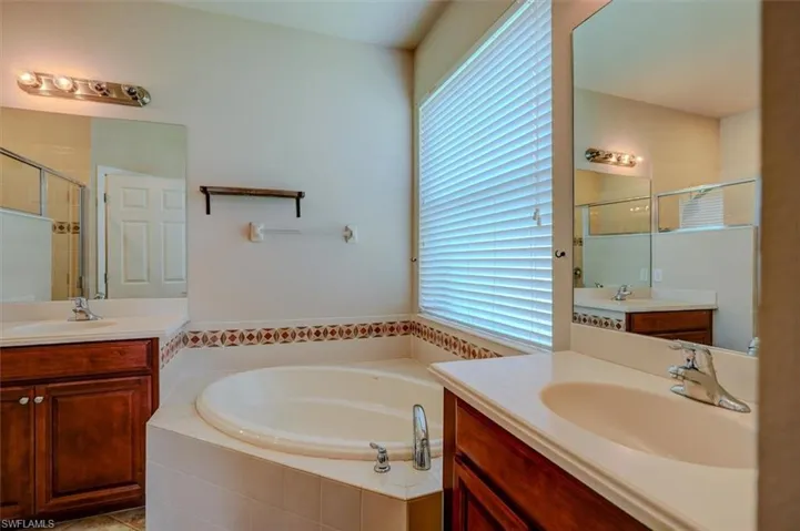 Bathroom with separate shower and tub, double sink vanity, and tile patterned flooring