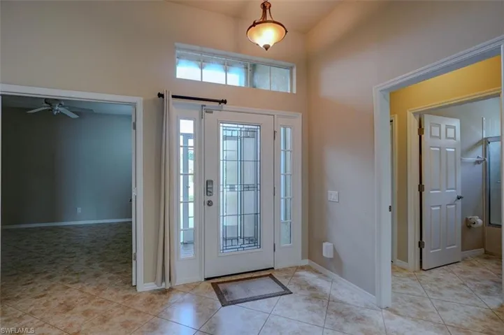 Tiled foyer entrance featuring a high ceiling and ceiling fan