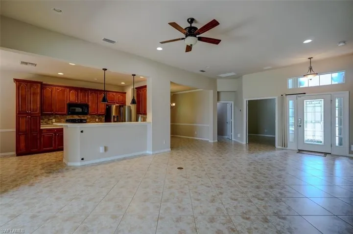 Unfurnished living room with light tile patterned floors and ceiling fan