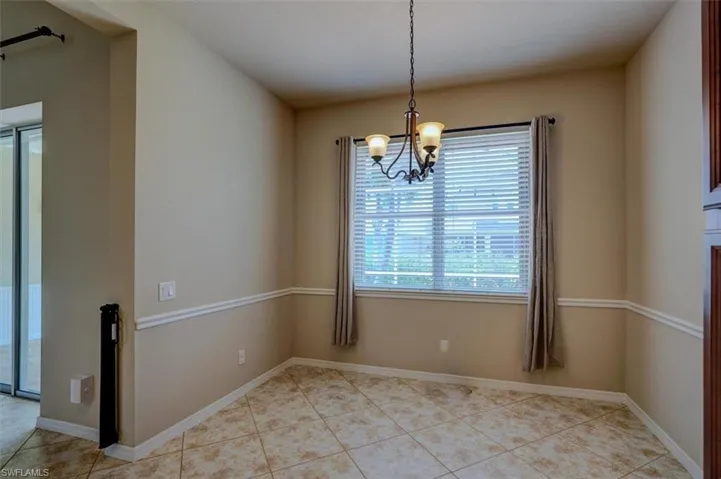 Empty room featuring an inviting chandelier and light tile patterned floors