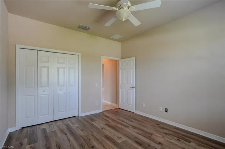 Unfurnished bedroom featuring ceiling fan, hardwood / wood-style floors, and a closet