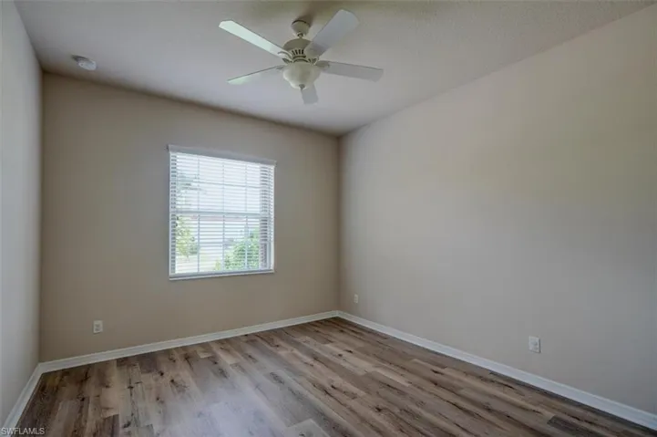 Spare room with hardwood / wood-style flooring and ceiling fan